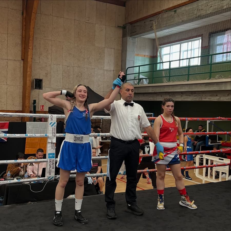 Combate femenino en el ring, el árbitro levanta el brazo de la ganadora